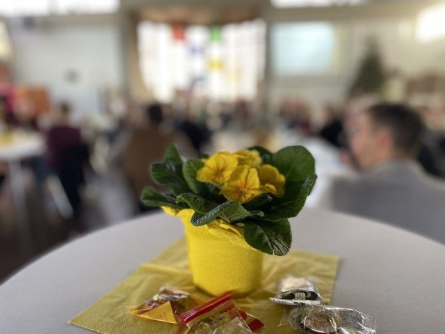 Eine Pflanze im Vordergrund, im Hintergrund die Gäste des Neujahrsempfang